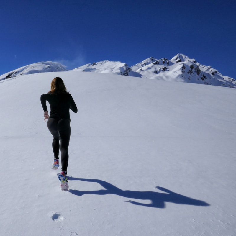 Woman running to top of mountain photo by Mauro Paillex